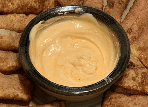 martha's peruvian chilli mayo salsa in a bowl surrounded by tequenos